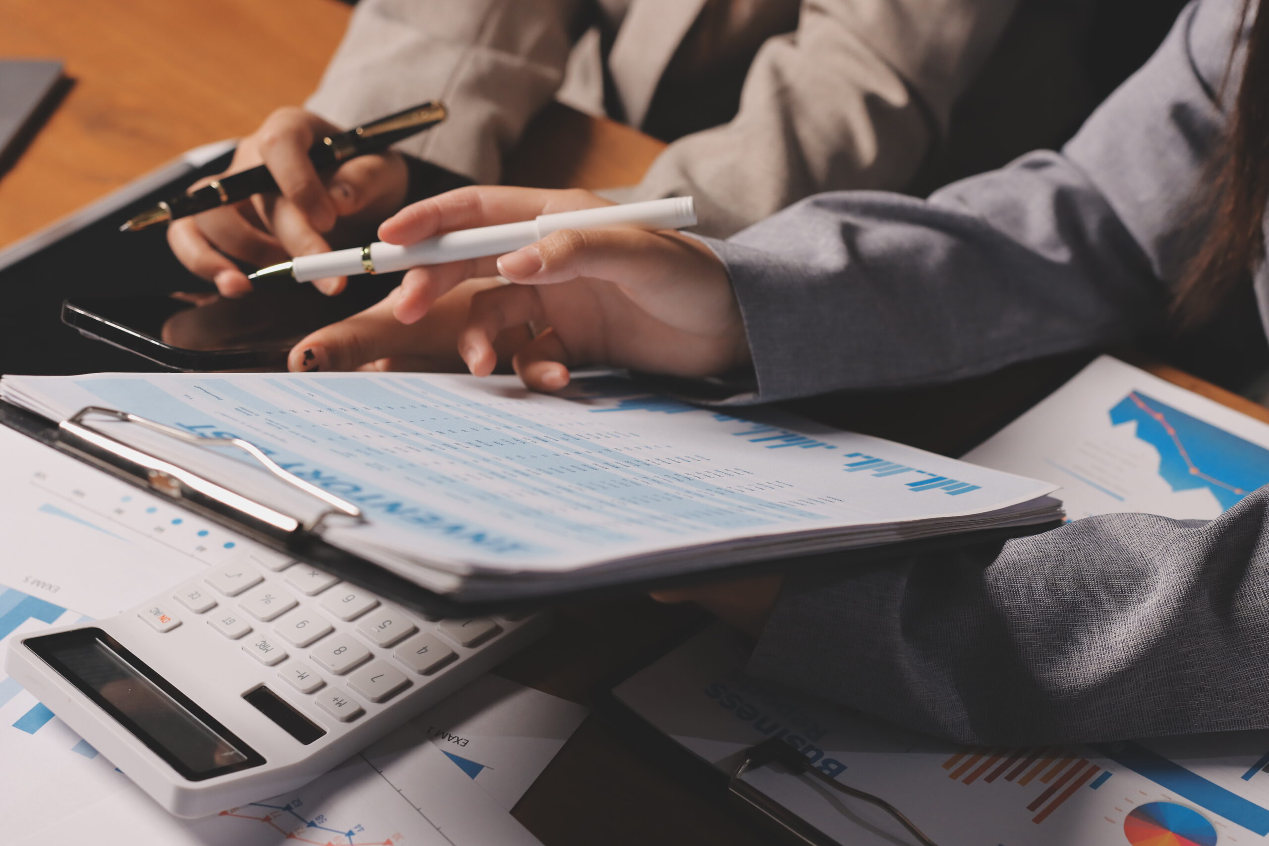 Group of confident business people point to graphs and charts to