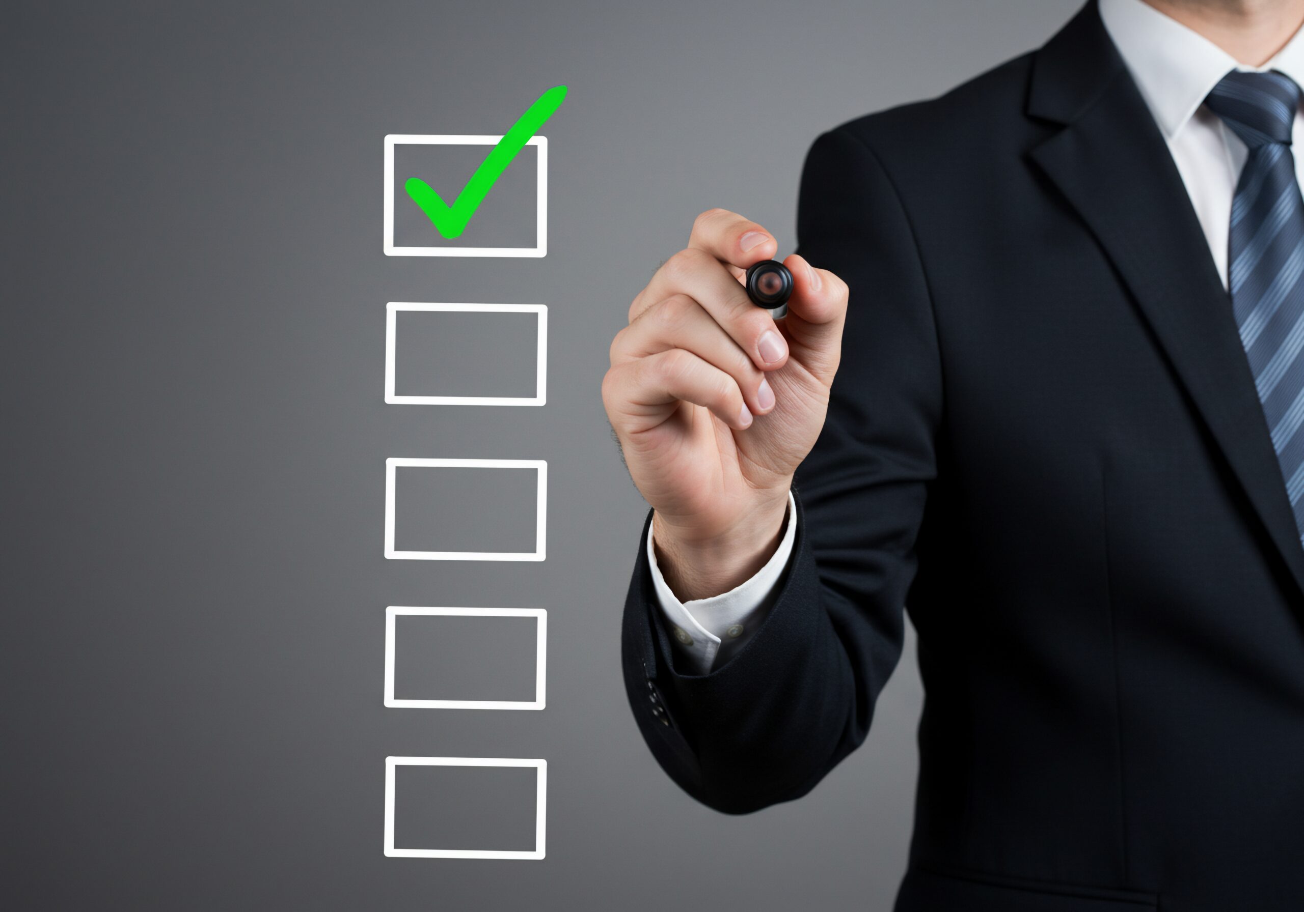Businessman checks task on checklist. Success, planning, background gray, for business